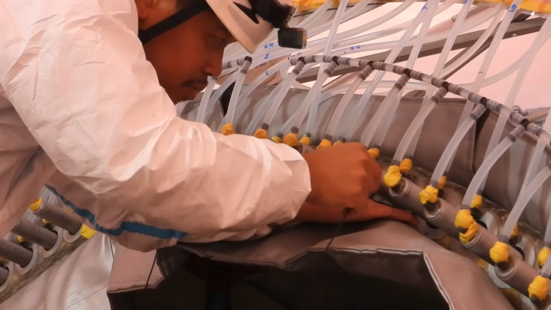 a man is working on infusion process. Epoxy is inserted into the bottom of the bushing via vacuum that fixes the bushing solidly
